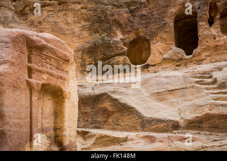 Tombeaux sculptés et grottes dans le siq passage à l'entrée de Pétra, Royaume hachémite de Jordanie, Moyen-Orient. Banque D'Images