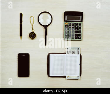 Ensemble d'articles de voyage y compris loupe, boussole, calculatrice, stylo, ordinateur portable, téléphone mobile et de l'argent. Planification d'overhea Banque D'Images