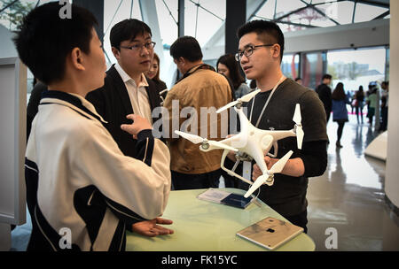 (160305) -- SHENZHEN, 5 mars 2016 (Xinhua) -- un membre du personnel (R) présente 4 fantôme drone développé par les grands consommateurs chinois-drone bouilloire DJI au flagship store de DJI à Shenzhen, province du Guangdong en Chine du sud, le 5 mars 2016. Shenzhen-DJI, fondée sur l'un des principaux fabricants de drones commerciaux et récréatifs pour la photographie aérienne et de la vidéographie, détient près de 70  % de part de marché dans le monde entier, avec l'Europe et l'Amérique du nom de ses plus gros clients. Le DJI Phantom 4 drone, qui a été lancé le 1 mars à New York, a fait ses débuts à Shenzhen samedi. (Xinhua/Mao tr Banque D'Images