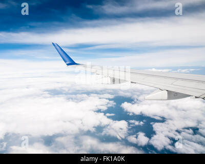 Aile d'avion au-dessus des nuages avec un ciel bleu Banque D'Images