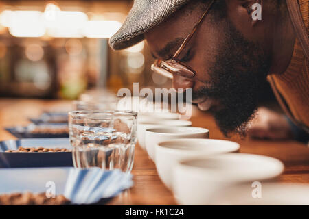 L'homme de l'Afrique de profiter de l'arôme de café frais à la dégustation Banque D'Images