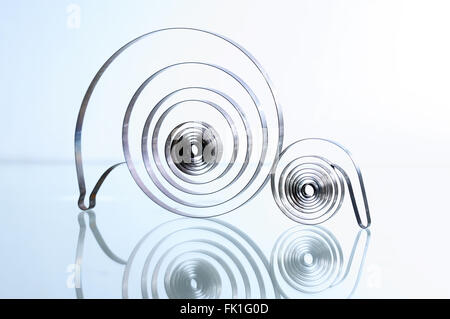 Contexte industriel. Deux vieux métal spirales sur une surface en verre avec réflexion Banque D'Images