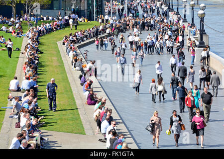 Soleil du printemps pour les touristes et les employés de bureau de profiter le long de la rive sud à côté de la Tamise, à l'Hôtel de Ville Southwark London England UK en savoir plus Banque D'Images