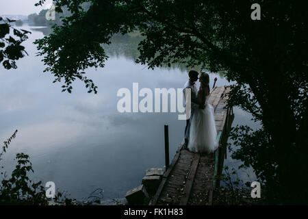 Couple de mariés sur la vieille jetée en bois Banque D'Images