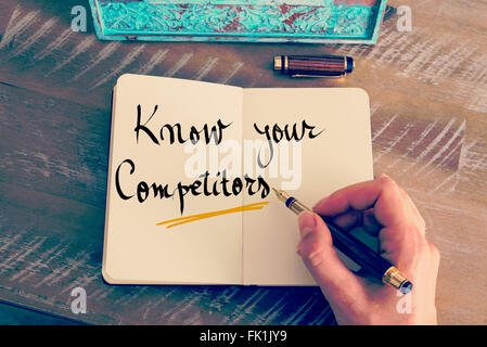 Effet rétro aux couleurs et image d'une femme d'écrire une note à la main avec un stylo sur un ordinateur portable. Texte manuscrit Connaissez vos concurrents comme concept d'entreprise de droit Banque D'Images