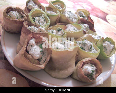 Rouleaux d'aubergines farcies au fromage cottage et verts. Sur la plaque, sur table Banque D'Images