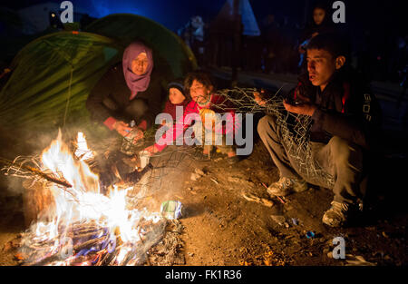 Idomeni, Grèce. Le 05 Mar, 2015. Les réfugiés rôtir un poulet sur un feu de camp dans le camp de réfugiés de l'Greek-Macedonian Idomeni à la frontière, de la Grèce, 05 mars 2015. Seul un petit nombre de réfugiés en provenance de Syrie et l'Irak sont encore en Macédoine chaque jour. Photo : KAY NIETFELD/dpa/Alamy Live News Banque D'Images