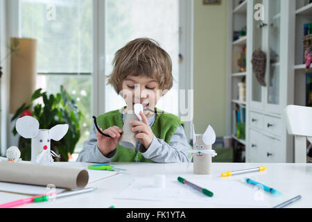 Petit garçon être créatif faisant des jouets de papier. Soutenir la créativité, l'apprentissage par la pratique, l'apprentissage par l'expérience. Banque D'Images