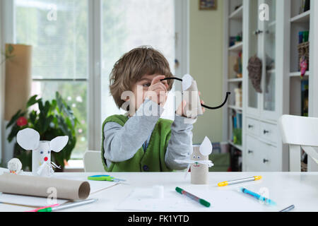 Petit garçon être créatif faisant des jouets de papier. Soutenir la créativité, l'apprentissage par la pratique, l'apprentissage par l'expérience. Banque D'Images