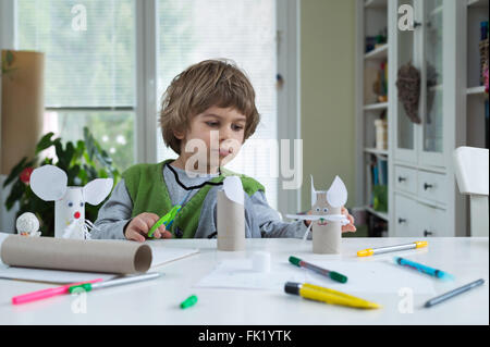 Petit garçon être créatif faisant des jouets de papier. Soutenir la créativité, l'apprentissage par la pratique, l'apprentissage par l'expérience. Banque D'Images