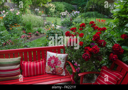 Donnant sur un jardin coloré avec des meubles rouges et de géraniums.au premier plan. Banque D'Images