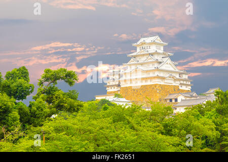 Magnifique coucher de soleil derrière récemment rénové Himeji-jo Château sur la cime des arbres vu de loin à Himeji, Japon après 2 Banque D'Images