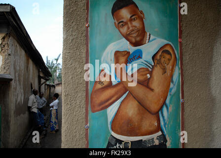 Un mur peint représentant un homme congolais tatoué montrant ses muscles dans un village de la province du Nord-Kivu en RD Congo Afrique. De nombreuses entreprises utilisent des peintures comme lingua franca visuel pour communiquer les biens qu'elles vendent Banque D'Images