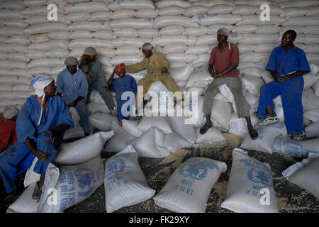 Les employés du Programme alimentaire mondial le PAM s'assoient sur de grands sacs de denrées alimentaires de base dans un centre logistique de la ville de Goma, dans la province du Nord-Kivu, RD Congo-Afrique Banque D'Images