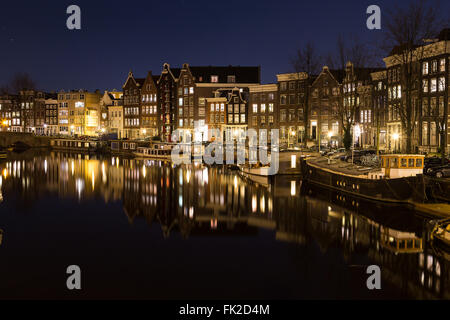 Vue le long du Canal en Waalseilandgracht Amsterdam dans la nuit. Des capacités, des bateaux et des réflexions peuvent être vus. Il y a de l'espace pour Banque D'Images