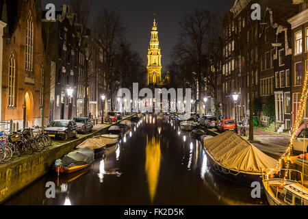 Vue le long du canal de Groenbuigwal vers l'église Zuiderkerk la nuit. Voitures, bateaux et bâtiments peuvent être vus. Banque D'Images