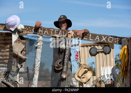 Karibe, un résident de Slab City, se tient à la porte de son campement, Niland, California USA Banque D'Images