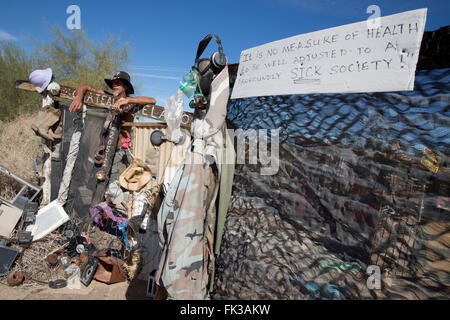 Karibe, un résident de Slab City, se tient à la porte de son campement, Niland, California USA Banque D'Images