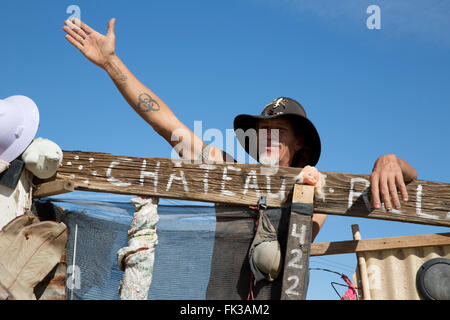 Karibe, un résident de Slab City, se tient à la porte de son campement, Niland, California USA Banque D'Images