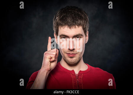 Jeune homme montre doigt vers le haut. Banque D'Images