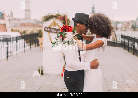 Happy black wedding couple hugging doucement sur le toit pendant la cérémonie de mariage Banque D'Images