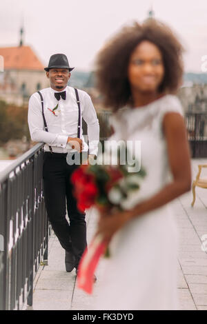 Groom noir élégant à se concentrer et à sa charmante épouse sur le toit. Cérémonie de mariage Banque D'Images