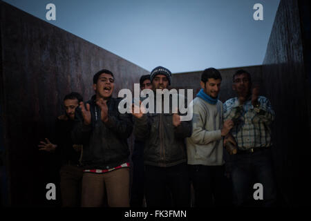 Idomeni, Grèce. 06 Mar, 2016. Les migrants sont célébrer après la distribution de bois de chauffage dans le camp d'Idomeni. Les migrants sur le chemin vers le camp de Bitola en Macédoine s'est félicité dans le camp d'Idomeni en Grèce en attente d'aller au-delà du point de contrôle à la frontière macédonienne. Des conditions d'extrême difficulté à le camp du Idomeni où la population a dépassé 10 000 unités. Pour le moment, il y a environ 400 réfugiés qui traversent la frontière en direction du camp de Bitola en Macédoine pour continuer leur voyage vers le nord dans l'Europe de l'Ouest. Crédit : Ivan Romano/Pacific Press/Alamy vivre Banque D'Images