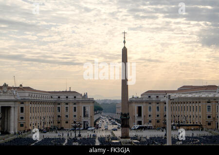 La croix en haut de l'obélisque à St Peters Square dans le Vatican est silhouetté contre certains matin soleil. Banque D'Images