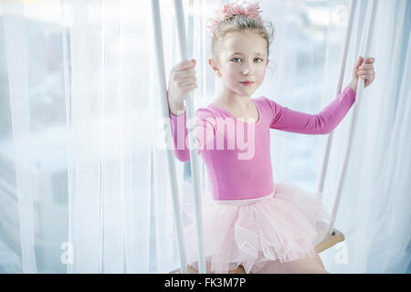 Triste petite fille assise sur une balançoire Banque D'Images