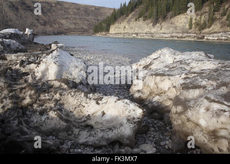 La neige glacée sale sur les rives de la rivière Bow dans le Parc Provincial Glenbow Ranch (Alberta, Canada). Banque D'Images