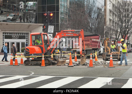 Les travailleurs de la construction à l'aide municipale - pelleteuse USA Banque D'Images