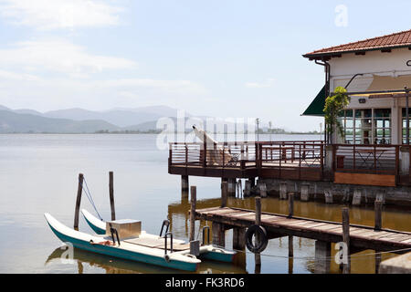 TORRE DEL LAGO, à proximité de la maison de Puccini. lac calme. Chambre avec baies vitrées sur pilotis. Pier, bateau. Collines en arrière-plan. Banque D'Images