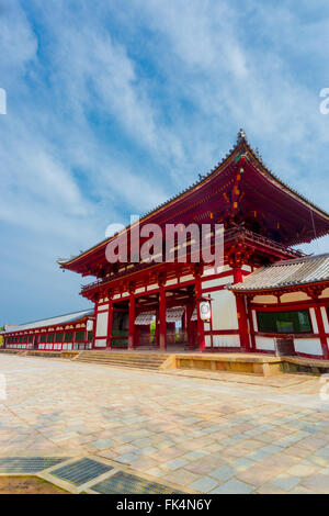 La porte rouge de façade inclinée ro-mon historique entrée de Temple Todai-ji, temple Todaiji, le Daibutsuden logement sur un beau ciel bleu morn Banque D'Images