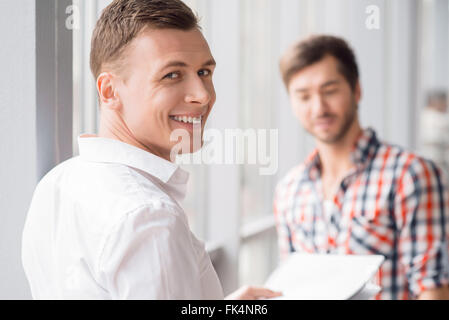 Cheerful man standing avec son collègue Banque D'Images