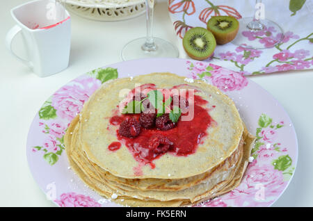 Pile de crêpes douces avec naturel de la vaseline et le baume de citron sur le dessus sur la plaque floral Banque D'Images