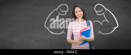 Image composite de college girl holding books with blurred students in park Banque D'Images