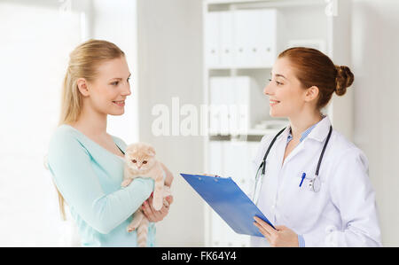 Femme heureuse avec cat et médecin à la clinique vétérinaire Banque D'Images