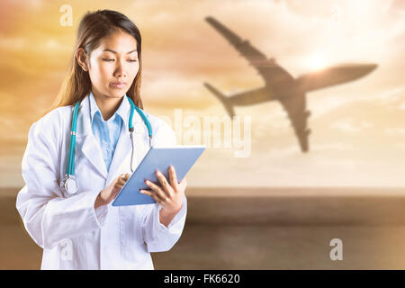 Composite image of doctor using tablet Banque D'Images