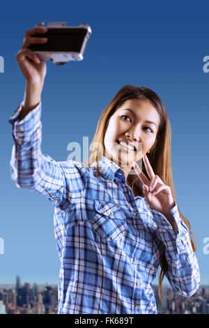 Composite image of asian woman taking photo avec l'appareil photo Banque D'Images