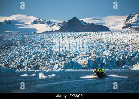 Zodiac excursion en bateau sur le lagon glaciaire du Jökulsárlón, avec Breidamerkurjokull et glacier Vatnajokull Ice Cap derrière, l'Islande Banque D'Images