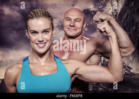 Image composite de Young cheerful man and woman flexing muscles Banque D'Images