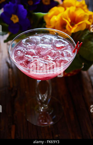 Cocktail cosmopolitan garni de glace sur une table en bois Banque D'Images
