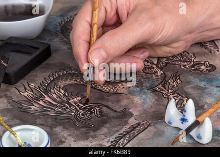 Artiste à l'aide du pinceau et encre calligraphie bloc de peindre un dragon chinois traditionnels Banque D'Images