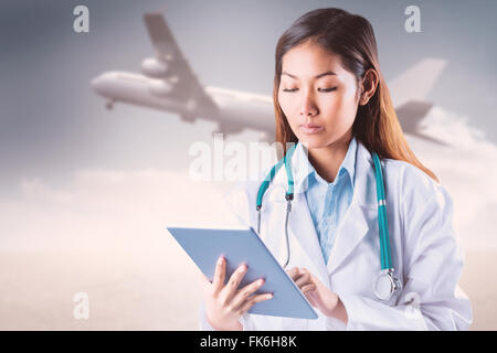 Composite image of doctor using tablet Banque D'Images