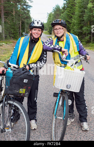 Les jeunes femmes avec des vélos et des drapeaux suédois Banque D'Images