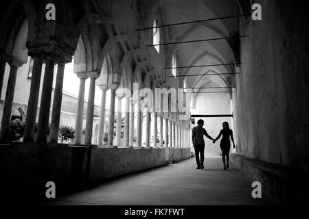 Silhouette d'un jeune couple dans un long couloir d'un ancien monastère. Arcs traditionnels en laissant la lumière, l'Italie, l'art Banque D'Images