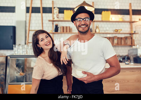 Portrait of happy young man and woman at cafe avec une tasse de café. Couple avec le café dans un restaurant. Banque D'Images