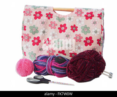 Tricot à motifs de fleurs roses/craft sac avec des aiguilles à tricoter, et rose, Bourgogne et la laine multicolore sur un fond blanc. Banque D'Images