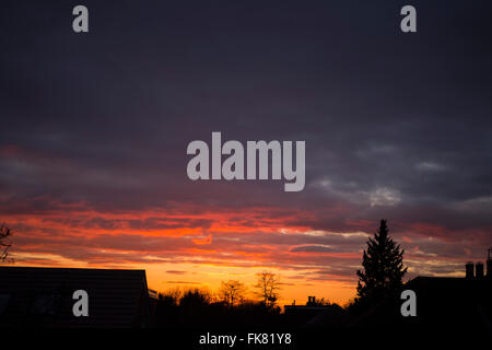 Wimbledon, Londres, Royaume-Uni. 7 mars, 2016. Ciel dégagé à l'ouest de Londres d'accueillir le soleil qui brille sur la base des nuages, silhouetting maisons de banlieue à l'avant-plan. Credit : Malcolm Park editorial/Alamy Live News Banque D'Images