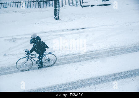 Montréal, CA, 7 mars 2016. Man riding bike sur la rue Rachel pendant une tempête de neige Banque D'Images